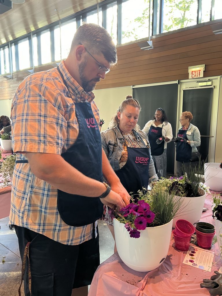 husband and wife planting containers together